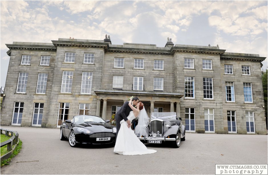haigh hall wedding bride and groom pose in front of building