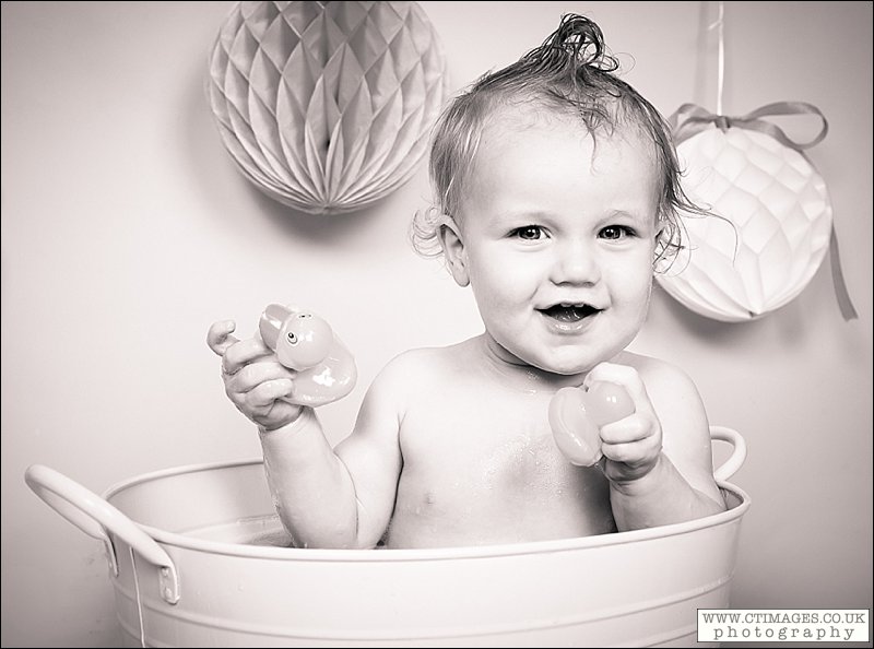 black and white image, baby with rubber ducks, bath time,