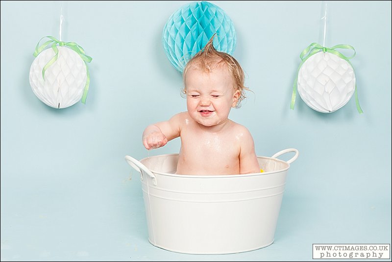 baby in bath tub, baby boy, blue backdrop, baby laughing in bath,
